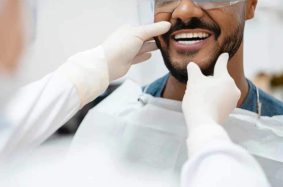 Dentist examining patient's teeth during dental checkup in clinical setting.