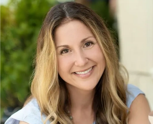 Woman smiling at camera in professional portrait for dental practice website